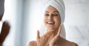Woman in towel touching her face